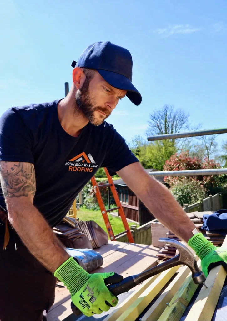 A John Morley & Son roofer nailing new timber battens on a roof