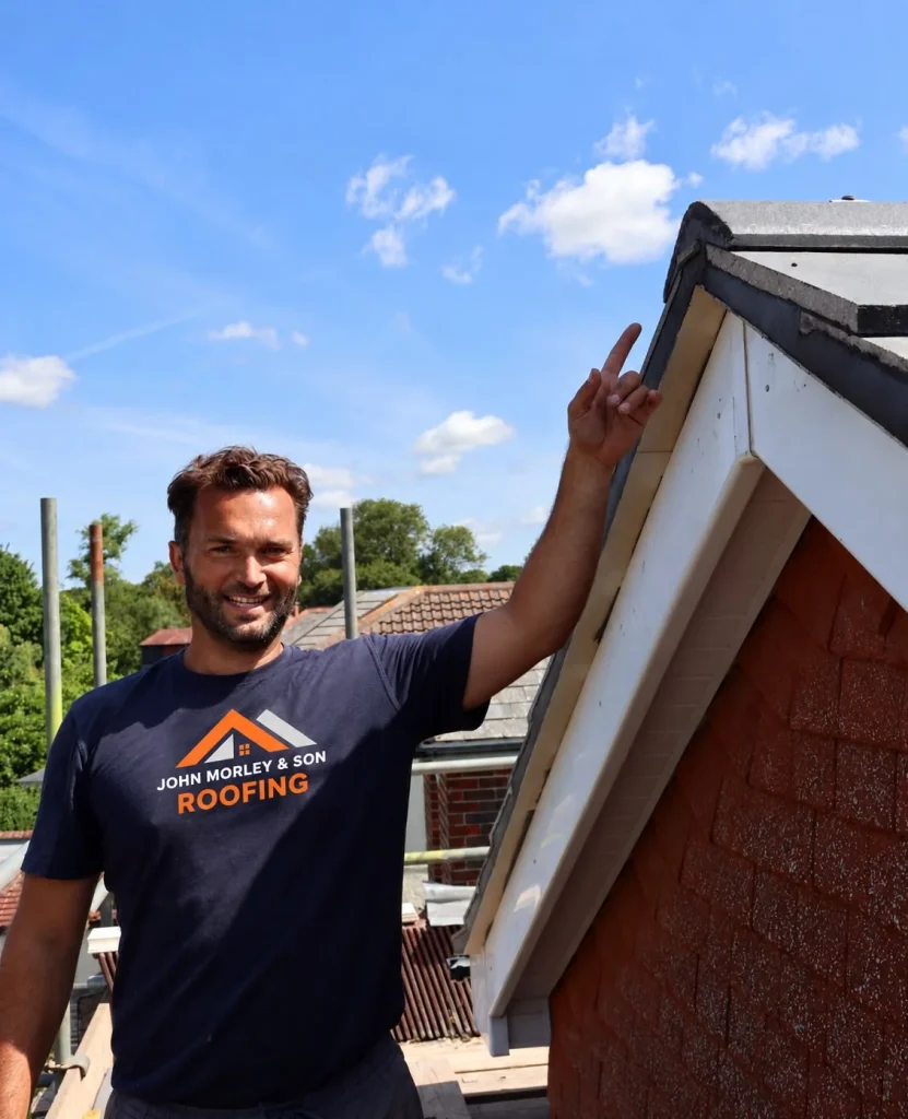 A John Morley & Son roofer pointing to a newly fitted white fascia and bargeboard
